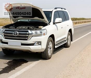 تویوتا با رنگ سفید و کاپوت بالا، دارای روغن ریزی شدید، تبلیغ تعمیرگاه تخصصی تویوتا تهران.